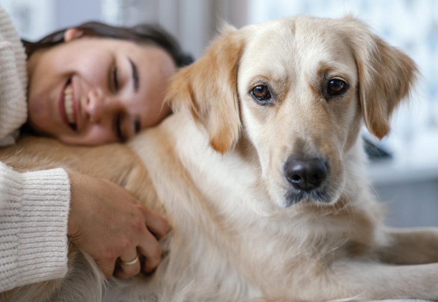 apartamentos la albarca hoznayo Mujer sonriente tumbada abrazando a su perro