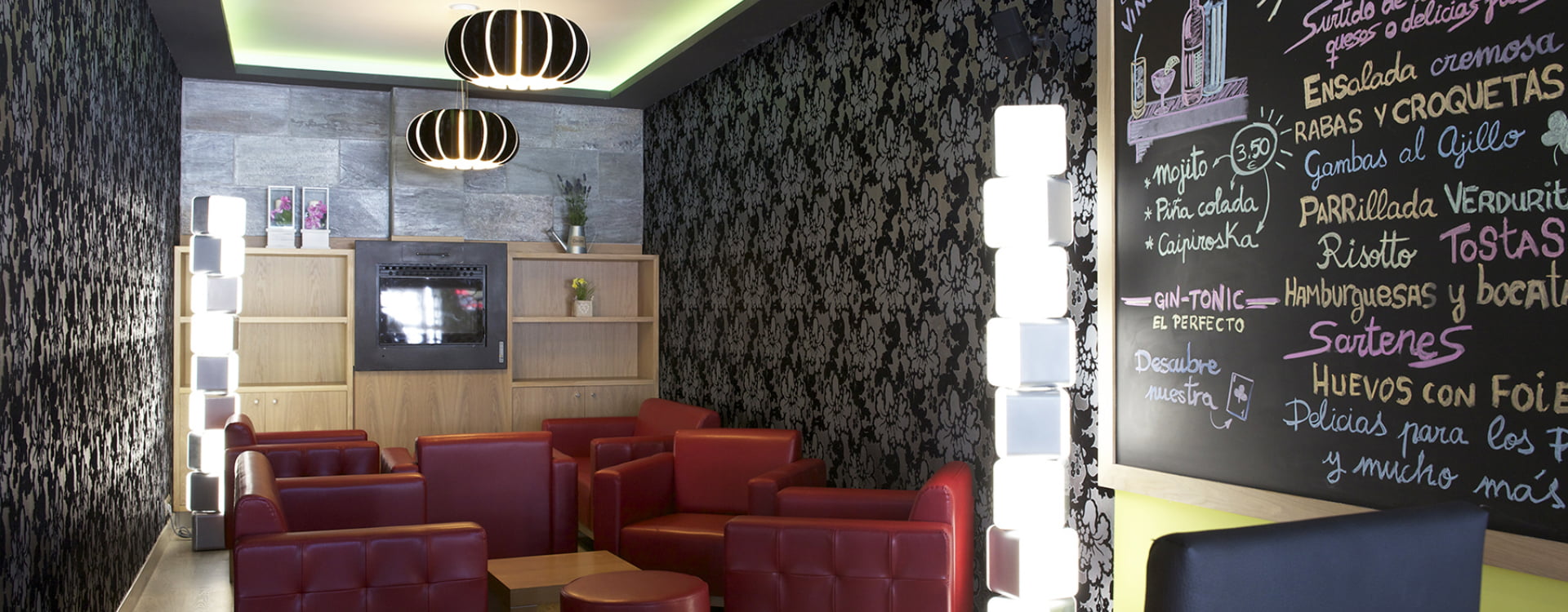 hotel los pasiegos image of the hotel's restaurant with red armchairs and floral decoration