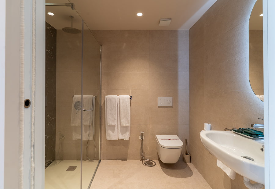 Bathroom with shower, toilet and washbasin Bathroom with shower tray, wc, large washbasin and backlit mirror