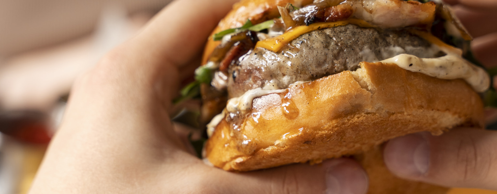 los pasiegos menu Person holding a cheeseburger with both hands
