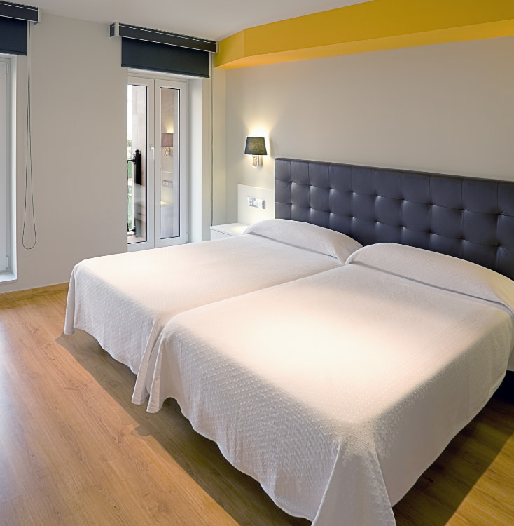 apartamentos spa villa pasiega hoznayo Imagen de una estancia con dos camas individuales y ventana con vistas exteriores